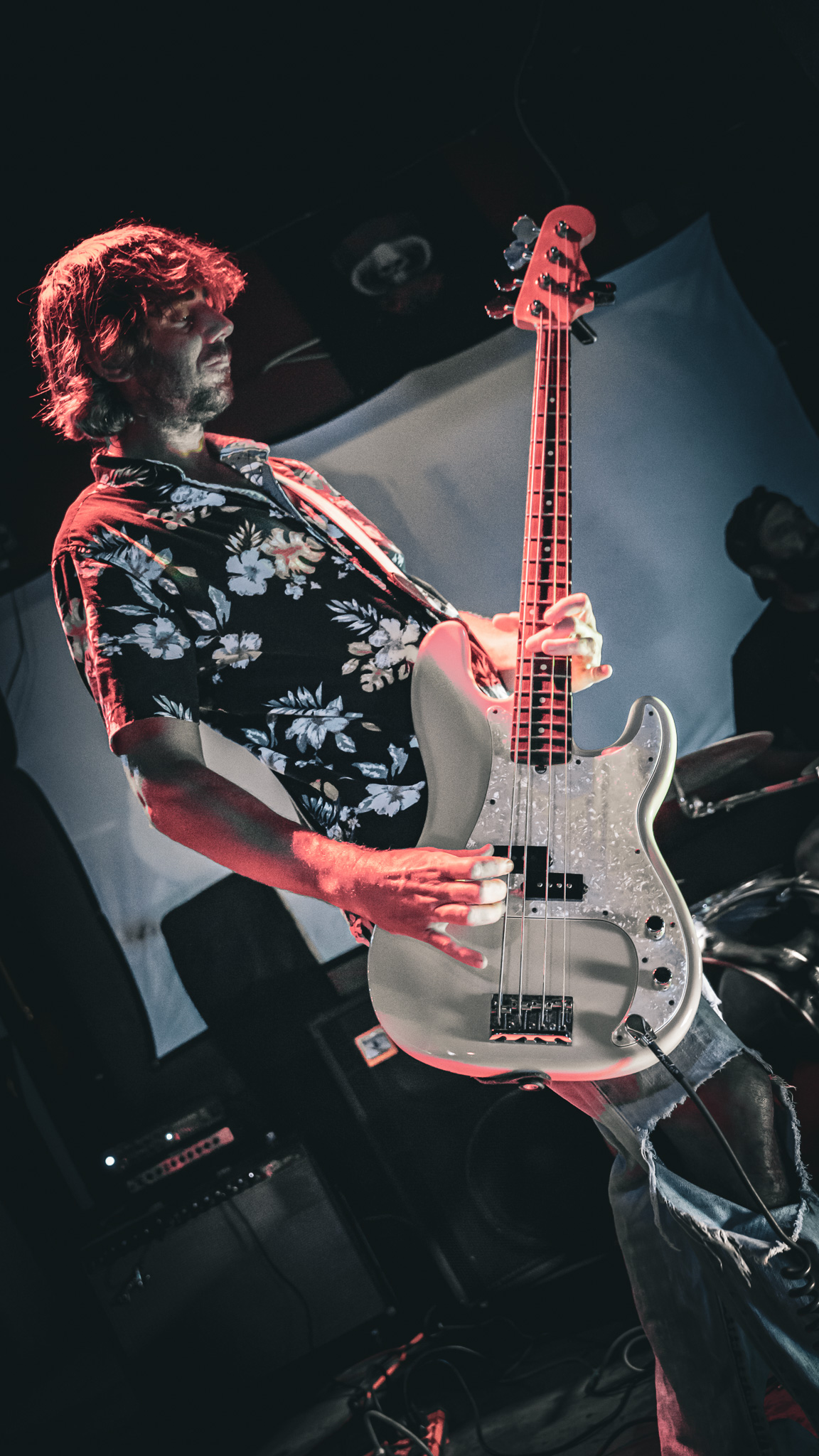Los Surfvivers guitarist and bassist under red stage lights