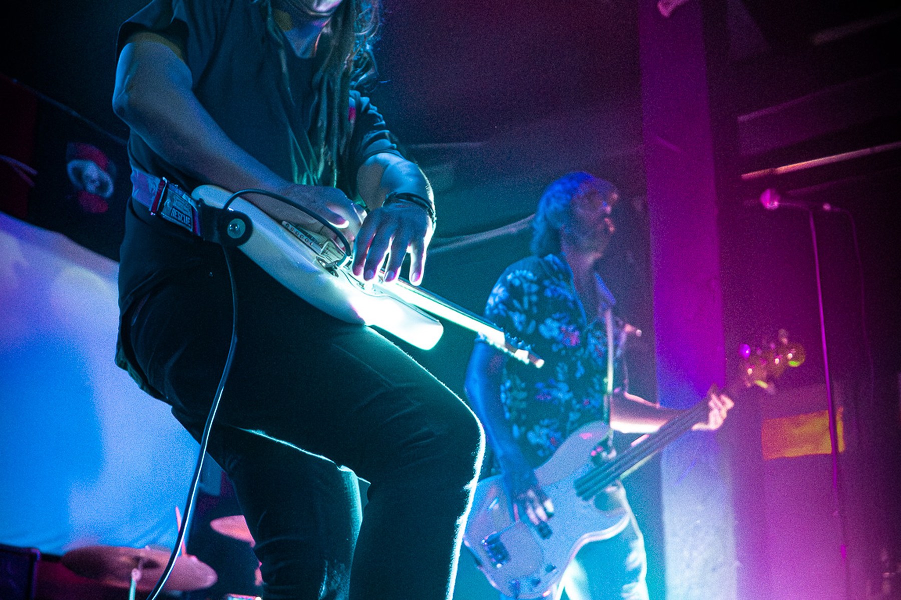 Guitarist playing in blue and pink stage lights