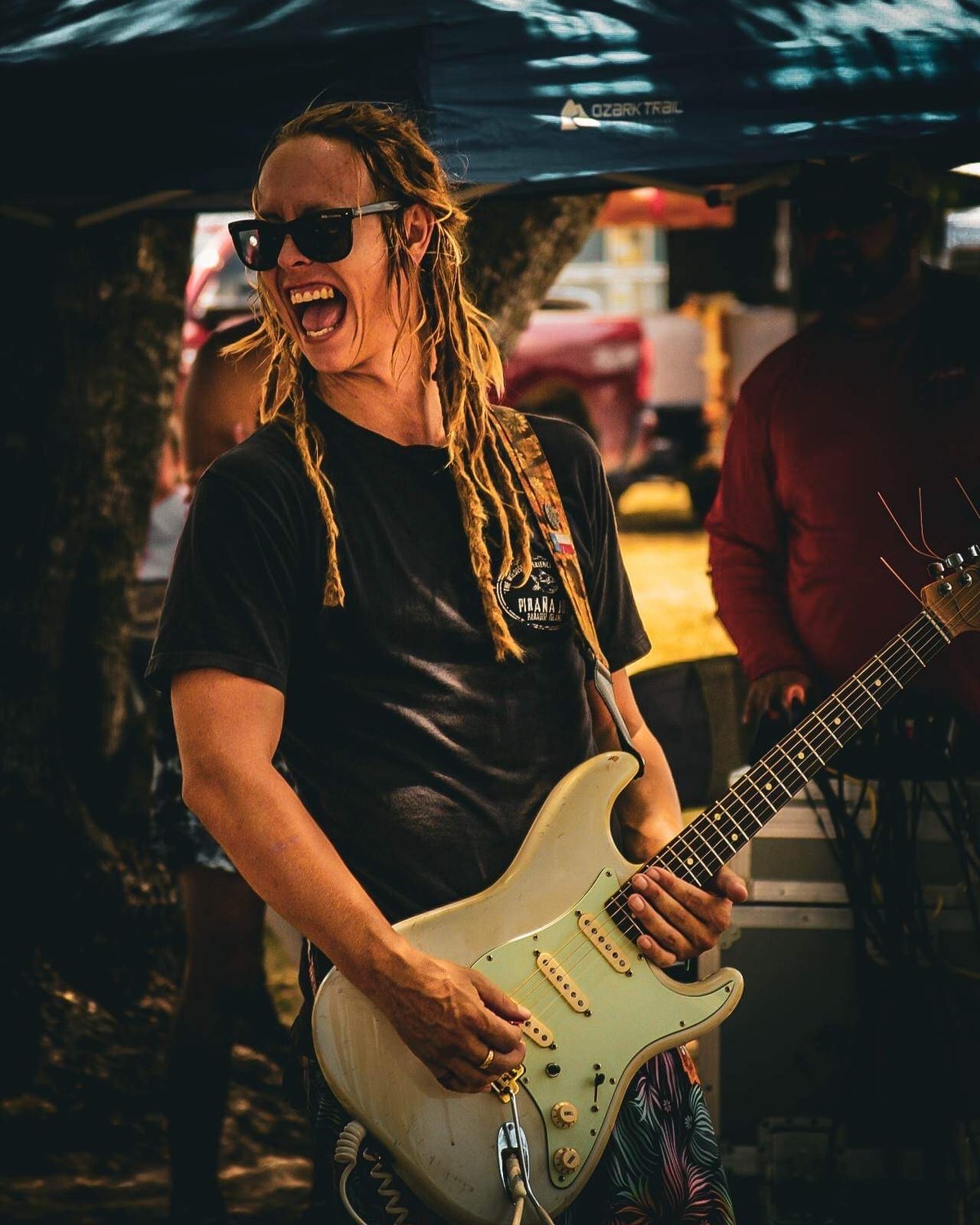 Guitarist smiling while playing a white guitar