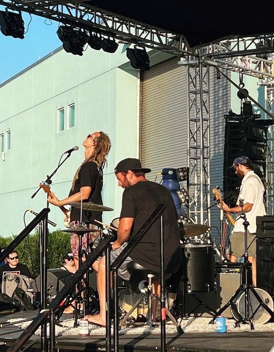 Los Surfvivers performing on an outdoor stage